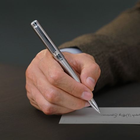 Four different pens in various colors and designs on a light background.